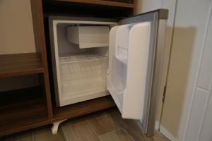 an empty refrigerator with its door open in a kitchen at Bebis Rooms in Orikum +13 photos