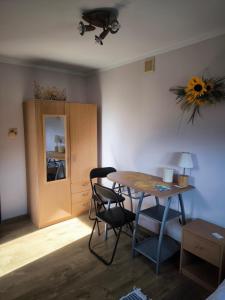 a room with a table and chairs and a cabinet at Agroturystyka Kuźnia in Neple
