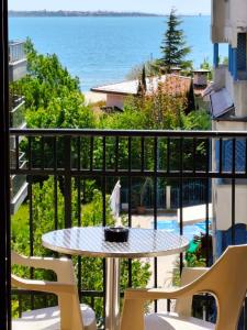a balcony with a table and chairs and the ocean at Хостел Бреза in Sunny Beach