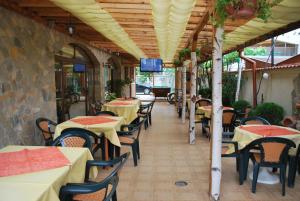 a restaurant with tables and chairs and a tv on the ceiling at Хостел Бреза in Sunny Beach