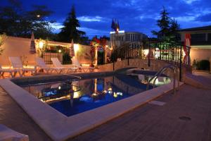 a swimming pool at night with chairs and lights at Хостел Бреза in Sunny Beach