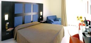 a bedroom with a bed and a blue chair at Hotel Admeto in Marinella di Selinunte +103 photos