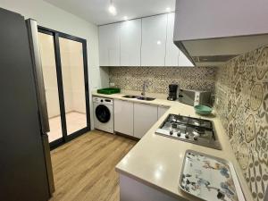 a kitchen with white cabinets and a stove top oven at JLKM Mindelo Central Residence in Mindelo
