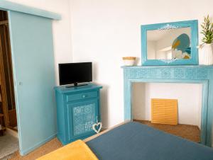 a room with a blue fireplace with a tv on it at Appartement bleu in Eymoutiers