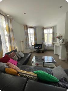 a living room with a black leather couch at Grace Family Home in Brussels