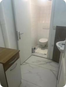 a white bathroom with a toilet and a sink at Grace Family Home in Brussels