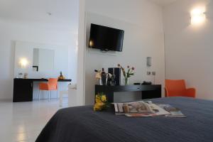 a bedroom with a bed with a tv on the wall at Hotel Admeto in Marinella di Selinunte