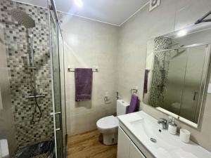 a bathroom with a toilet and a sink and a shower at JLKM Mindelo Central Residence in Mindelo