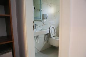 a bathroom with a sink and a toilet at Bebis Rooms in Orikum