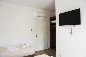 a bedroom with a bed and a flat screen tv at Bebis Rooms in Orikum