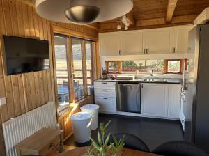 a kitchen with white cabinets and a sink and a tv at Summerhouse Torfalundur in Blönduós