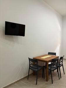 a table with chairs and a television on a wall at B&B Mamie in Bellizzi