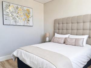 a bedroom with a large bed and a painting on the wall at Movic's Modern Airbnb in Windhoek