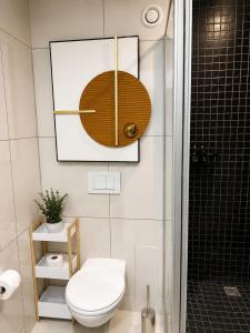 a bathroom with a toilet and a clock on the wall at Movic's Modern Airbnb in Windhoek +3 photos