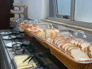 a counter with baskets of bread and other foods at Hotel Santorine Plaza - Itabira - Próximo a Fundação Cultural Carlos Drummond Andrade in Itabira