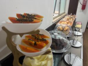 a table with two bowls of food on a counter at Hotel Santorine Plaza - Itabira - Próximo a Fundação Cultural Carlos Drummond Andrade in Itabira