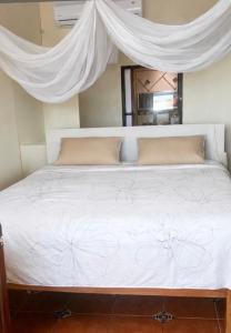 a bed with a white bedspread with flowers on it at Beachfront - Private Floor, 4 Rooms - Casa 3 Lunas in Playa Agua Blanca +9 photos