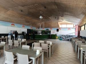 ein Restaurant mit Tischen, Stühlen und einer Theke in der Unterkunft Bariscan Hotel in Mahmutlar