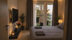 a bedroom with a bed and a large window at Citadella Luxury Lakefront Apartment with Terrace in Siófok