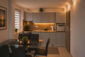 a kitchen with a table and a dining room at Citadella Luxury Lakefront Apartment with Terrace in Siófok