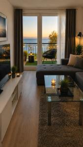 a living room with a couch and a table at Citadella Luxury Lakefront Apartment with Terrace in Siófok