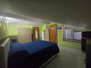 a bedroom with a blue bed and green walls at A Casa di Nonna in Riposto