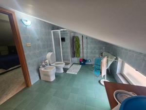 a bathroom with two toilets and a bath tub at A Casa di Nonna in Riposto