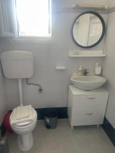 a bathroom with a toilet and a sink and a mirror at Melina's sunset-Cozy studio with amazing sea view and sunset in Myrties +8 photos