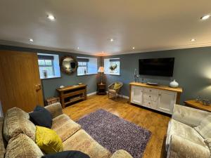 a living room with a couch and a flat screen tv at Shepherds Barn in Beamish