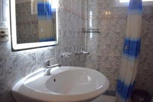 a bathroom with a white sink and a mirror at Old Bridge Guest House in Gjirokastër +68 photos