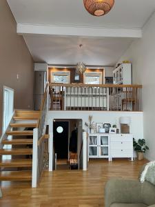 a living room with a staircase and a stair case at Apartment with great sunset view! in Lyngdal