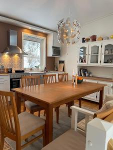 a kitchen and dining room with a wooden table and chairs at Apartment with great sunset view! in Lyngdal +16 photos