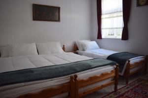 a bedroom with two twin beds and a window at Old Bridge Guest House in Gjirokastër