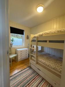 a bedroom with two bunk beds and a window at Apartment with great sunset view! in Lyngdal