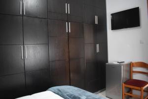 a bedroom with dark wooden cabinets and a tv at Old Bridge Guest House in Gjirokastër