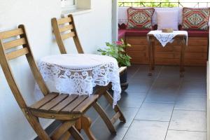 a wooden chair with a table with a white table cloth at Old Bridge Guest House in Gjirokastër