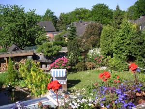 einen Garten mit Blumen und einem Stuhl in der Mitte in der Unterkunft Haus Wiesel in Bispingen