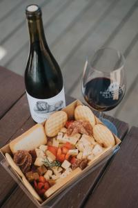 a plate of food next to a bottle of wine at Casa Misiones Glamping in Valle de Guadalupe