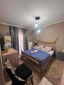 a bedroom with a bed and a chair at Dimitris Apartment in Karditsa