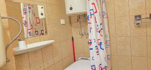 a bathroom with a shower with a white and red shower curtain at Studio Rose in Gajac