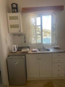 a kitchen with a sink and a window at Melina's sunset-Cozy studio with amazing sea view and sunset in Myrties