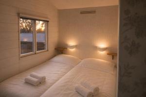 a bedroom with a large white bed with two pillows at Tiny house met Coldtub 4pers The Firefly in Amblève