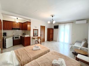 a living room with two beds and a kitchen at Rena Studios in Paleokastritsa