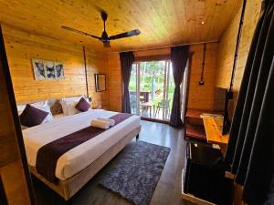 a bedroom with a large bed in a wooden room at Seclude Eco Cottages in Anjuna