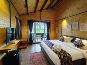 a bedroom with a large bed and a television at Seclude Eco Cottages in Anjuna