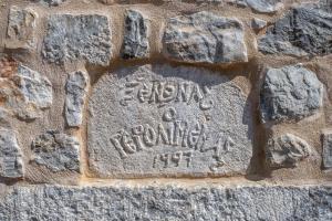 eine Steininschrift an der Seite einer Steinmauer in der Unterkunft Pyrgoi Theodorakaki: O Gerolimenas in Yerolimin