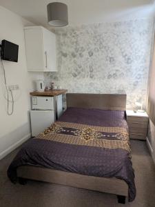a small bedroom with a bed in a room at Corby Double & En-suite Rooms NN17 2LZ area Ideal Contractors Short & Long stays Opposite Lodge Park Leisure Center in Corby