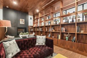 a living room with a leather couch and book shelves at Sentral West Midtown at Star Metals in Atlanta