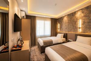 a hotel room with two beds and a television at Huzur Apart Hotel in Istanbul
