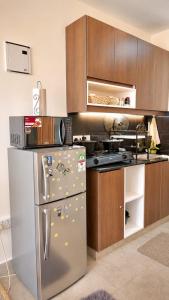 a kitchen with a stainless steel refrigerator and wooden cabinets at Ongata Rongai Pool Studio Near Nairobi National Park and giraffe center in Ongata Rongai 